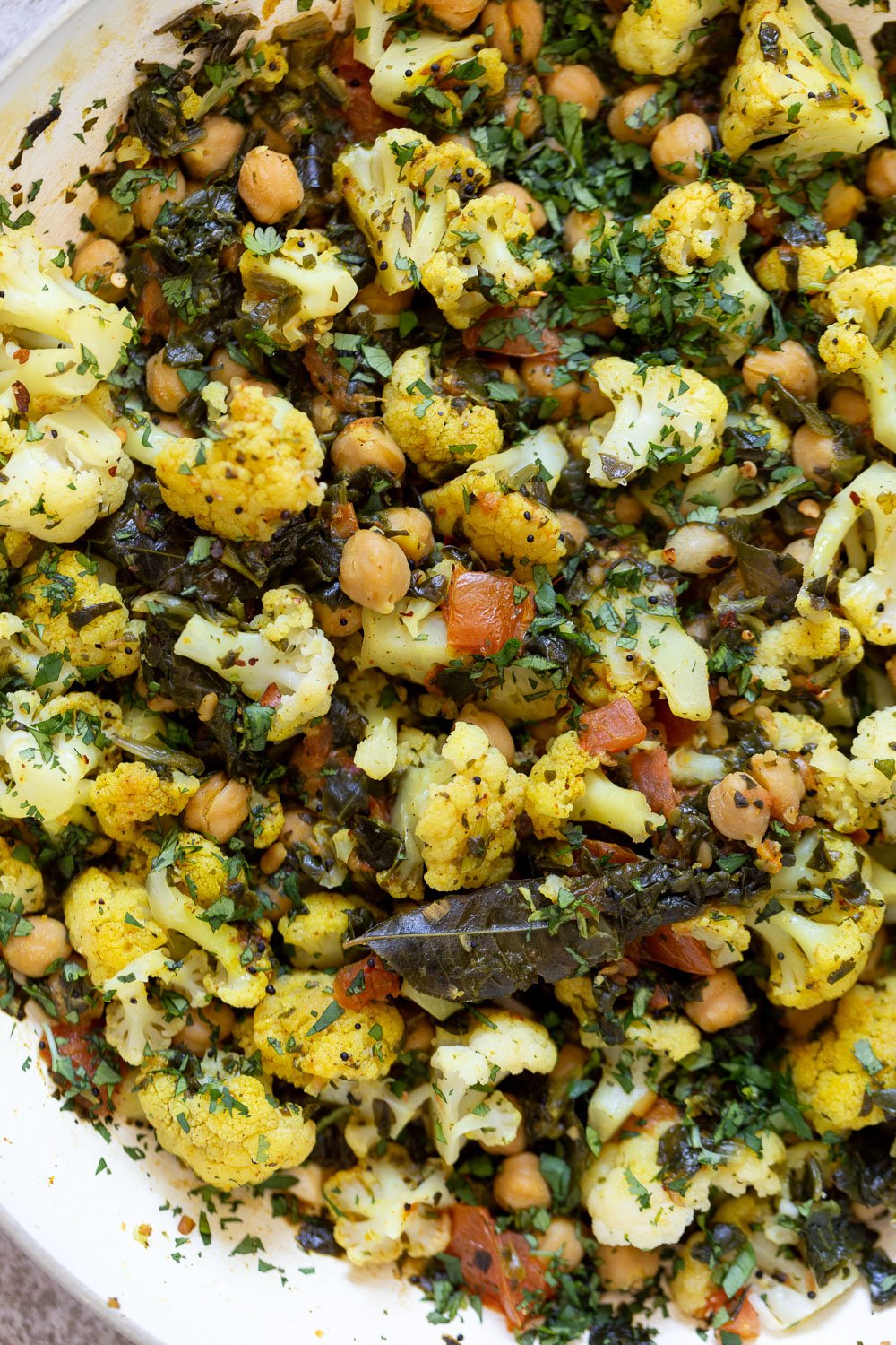 spinach and chickpeas close-up overhead shot of a frying pan with cauliflower, chickpeas and spinach saute