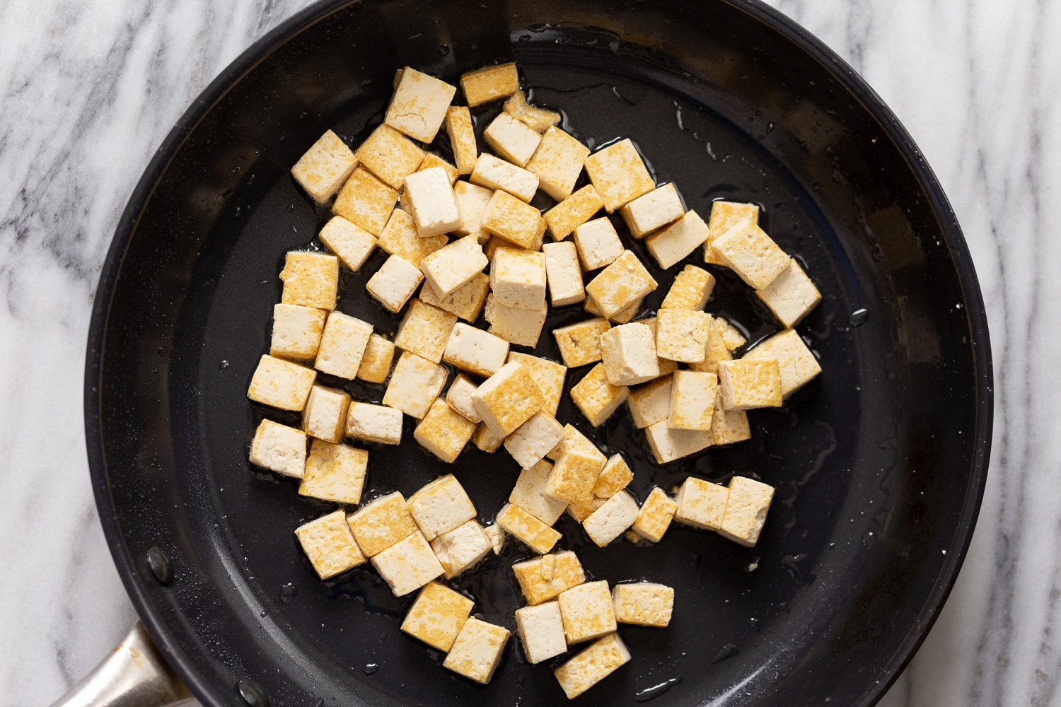 tofu in sauce overhead shot of a skillet with oan-fried tofu cubes