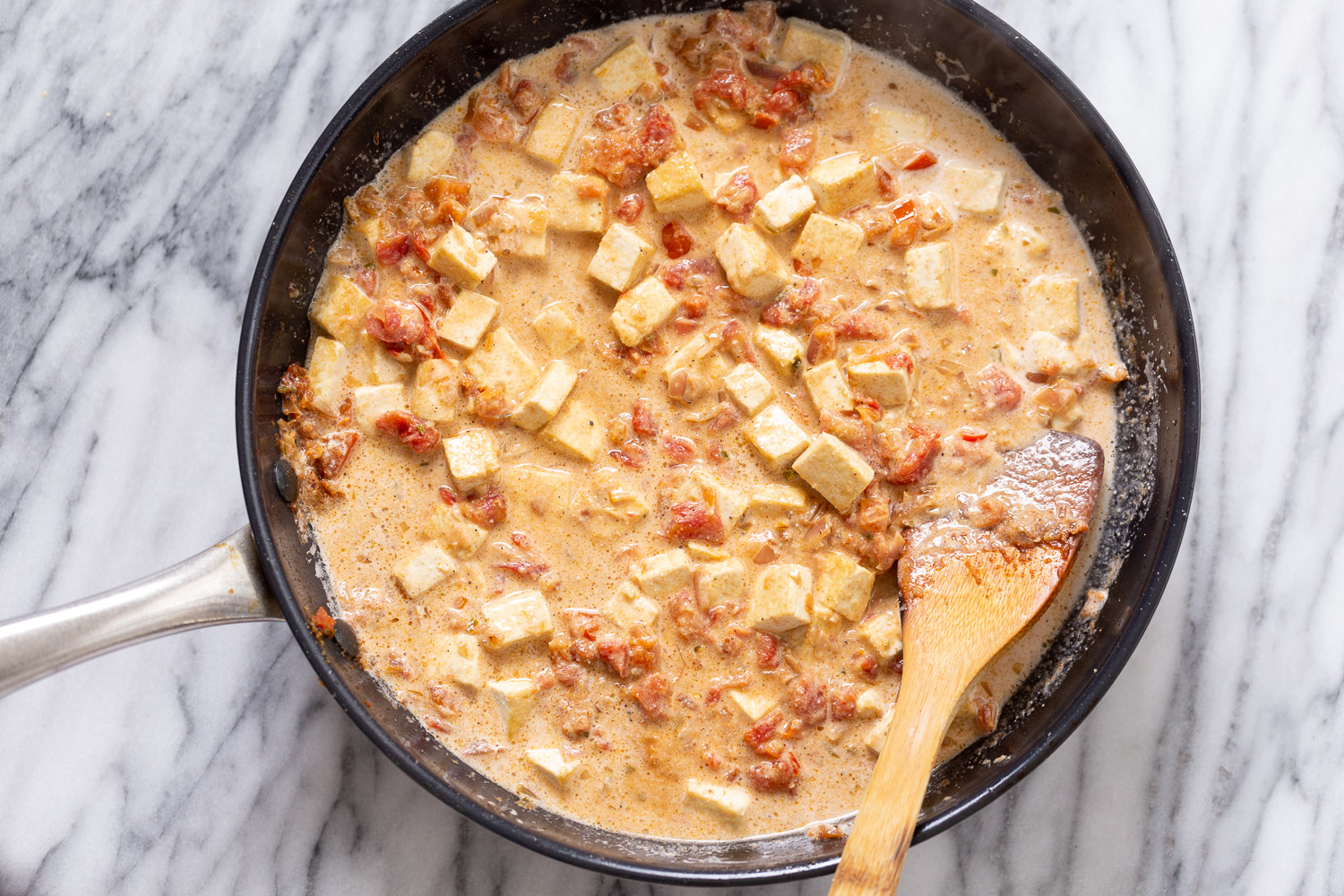 tofu in sauce Dum Tofu Paneer Kali Mirch being stirred in a skillet