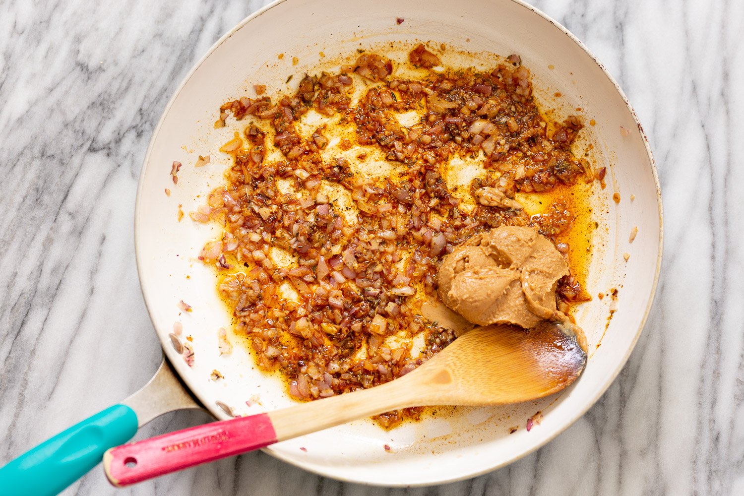 Peanut Stew minced onions being sauteed in a frying pan with spices and peanut butter for making African peanut stew