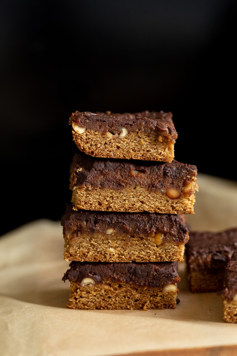 snickers bar recipe side view of a stack of healthy homemade vegan snickers bars with date caramel