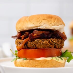 side view if vegan chickpea burger with caramelized onions and hummus