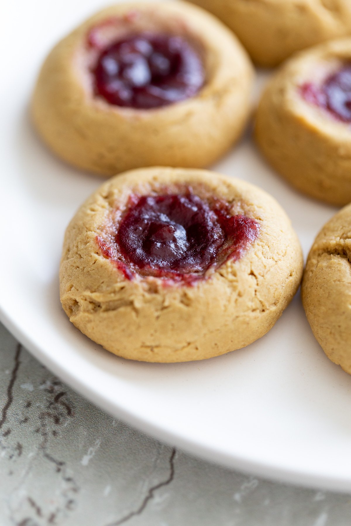 thumbprint cookies side view of a plate with vegan pb & j thumbprint cookies