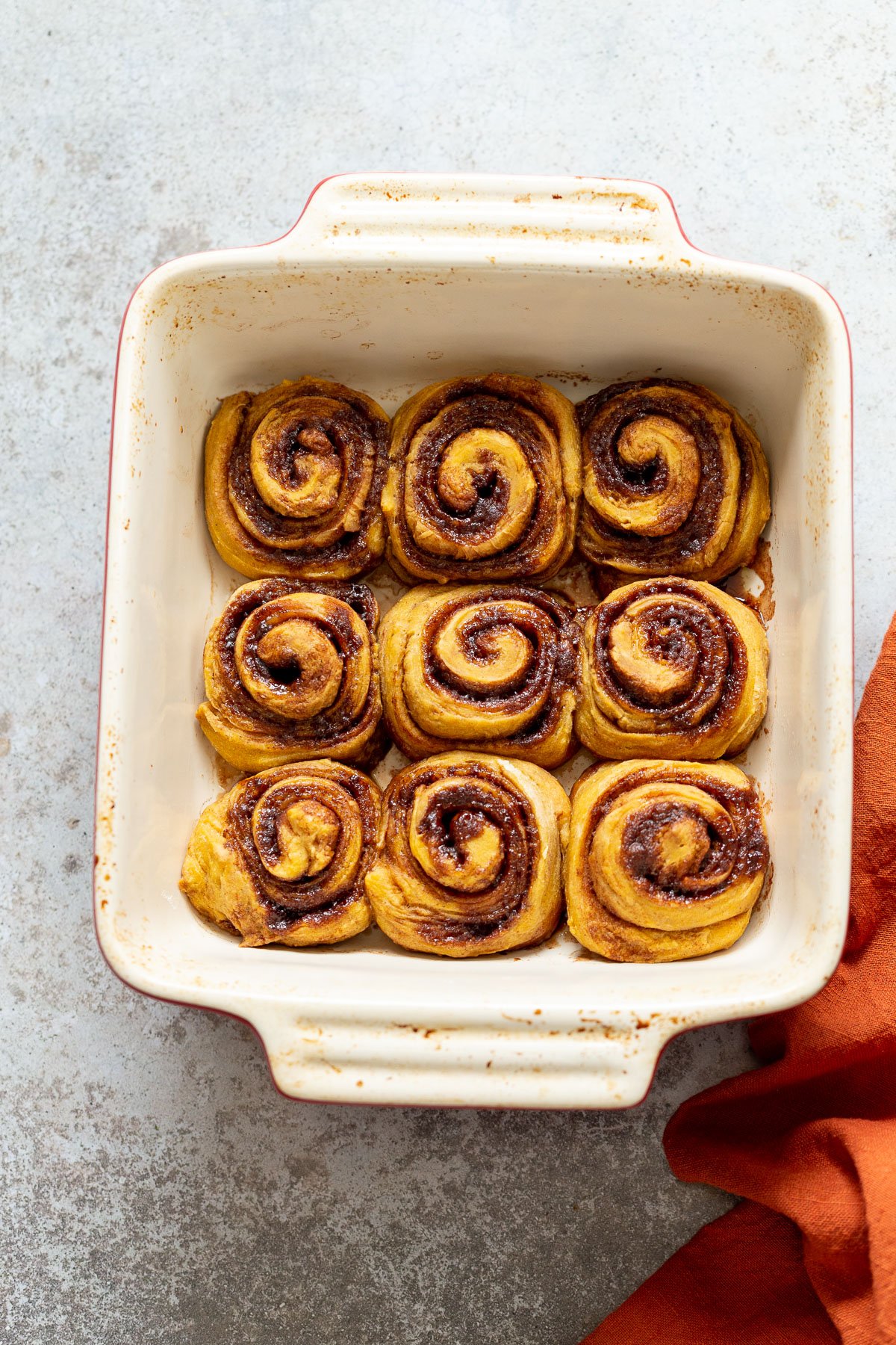 no yeast cinnamon rolls  overhead shot of a casserole dish with freshly baked cinnamon rolls