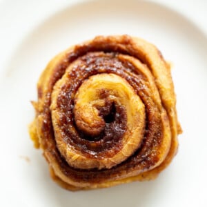 overhead shot of a vegan no yeast cinnamon roll with sweet potato on a white plate