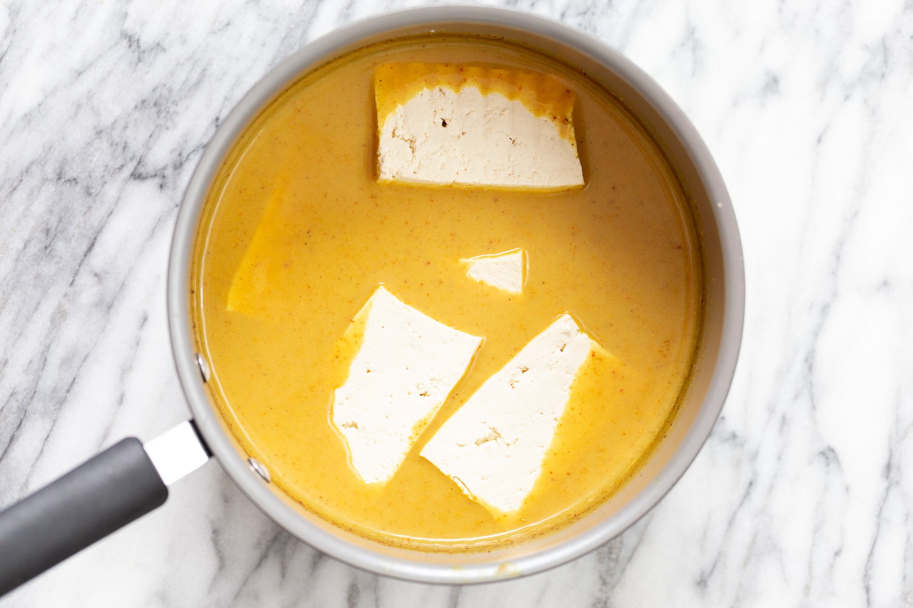 katsu curry tofu slices being dipped into katsu curry sauce to make tofu katsu curry recipe