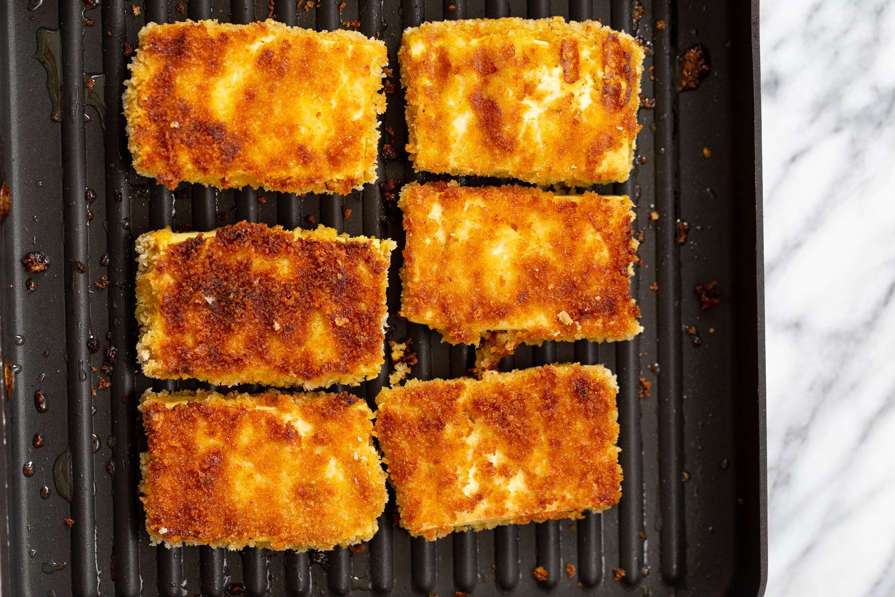 katsu curry  breaded tofu sliced being fried in a grilling pan