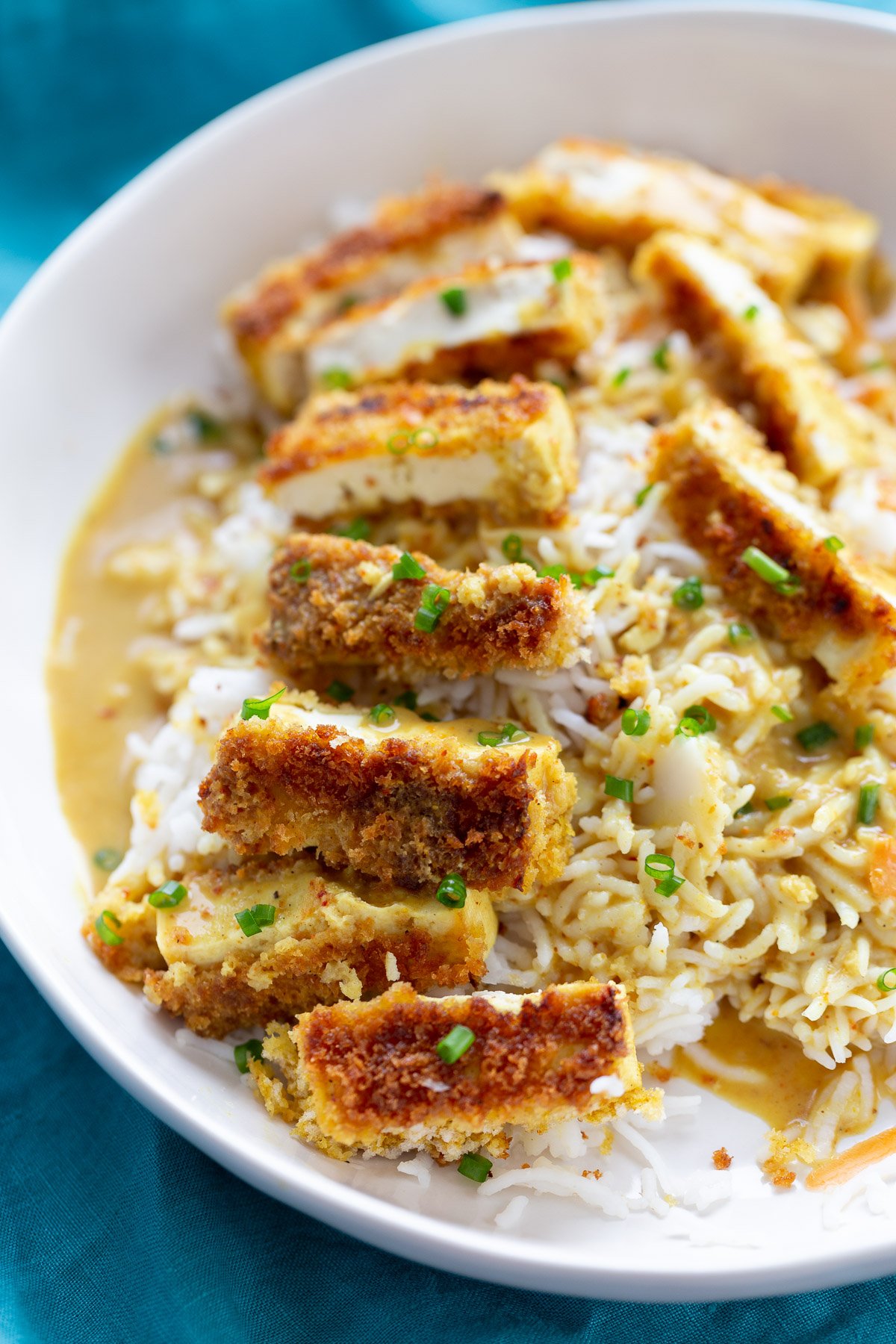 katsu curry a bowl of rice topped with breaded pan-fried tofu slices and drizzled with Japanese curry sauce