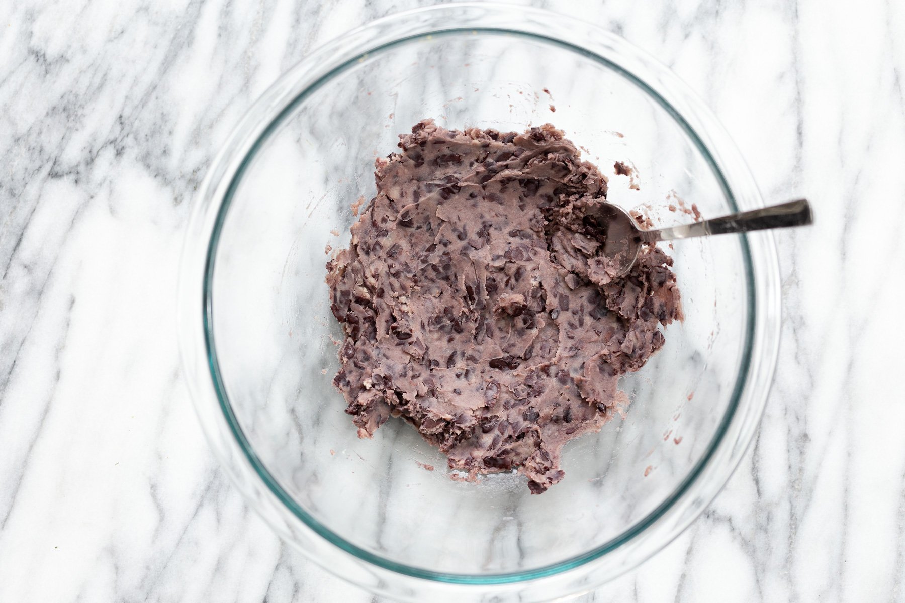 quinoa burger mashed black beans in a glass bowl