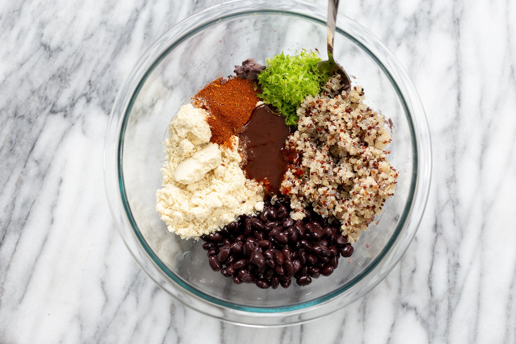 quinoa burger ingredients for making black bean quinoa patties gathered in a glass bowl