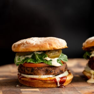 side view of a vegan black bean quinoa burger topped with vegan ranch and jalapenos
