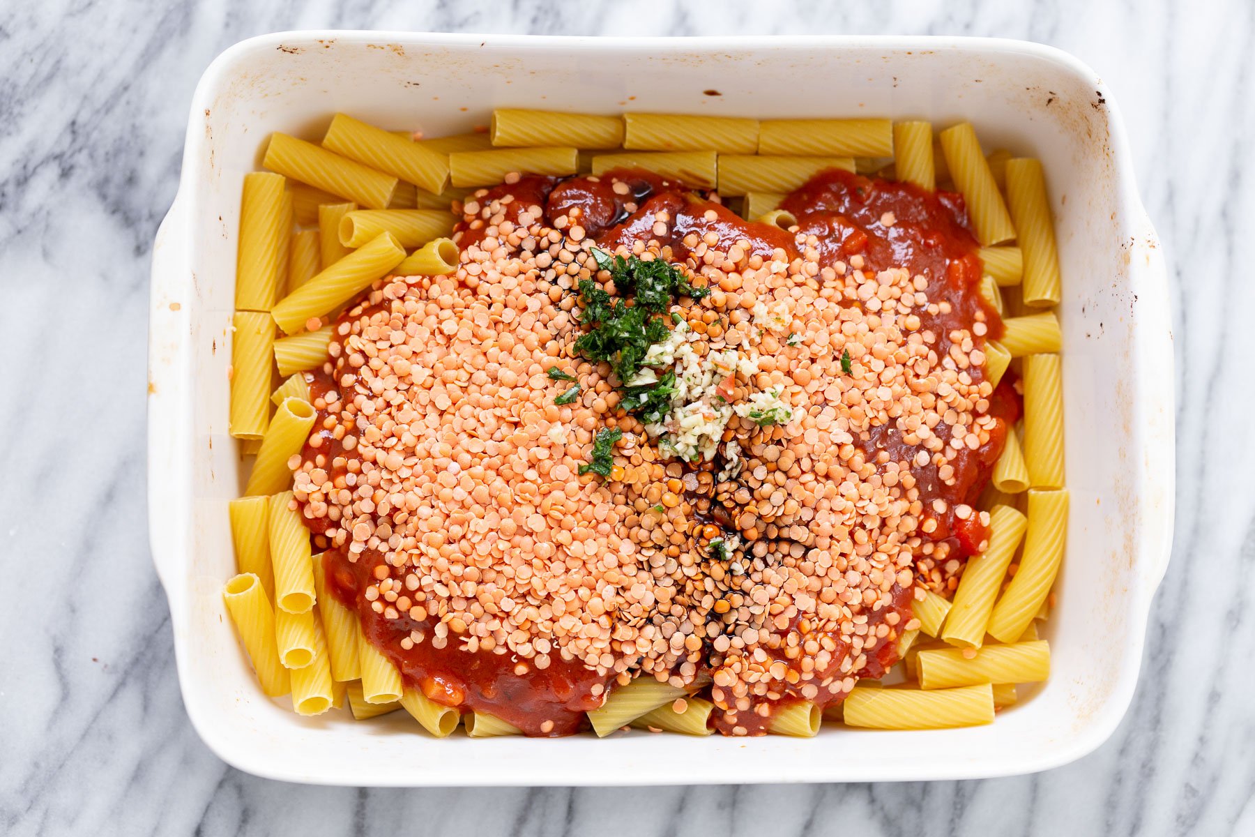 baked rigatoni overhead shot of casserole dish with raw pasta, marinara and red lentils