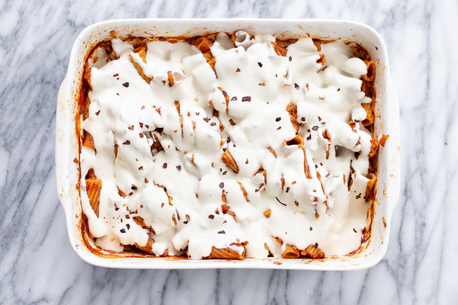 baked rigatoni Vegan Tofu Mozzarella Cheese sauce poured on top of baked rigatoni