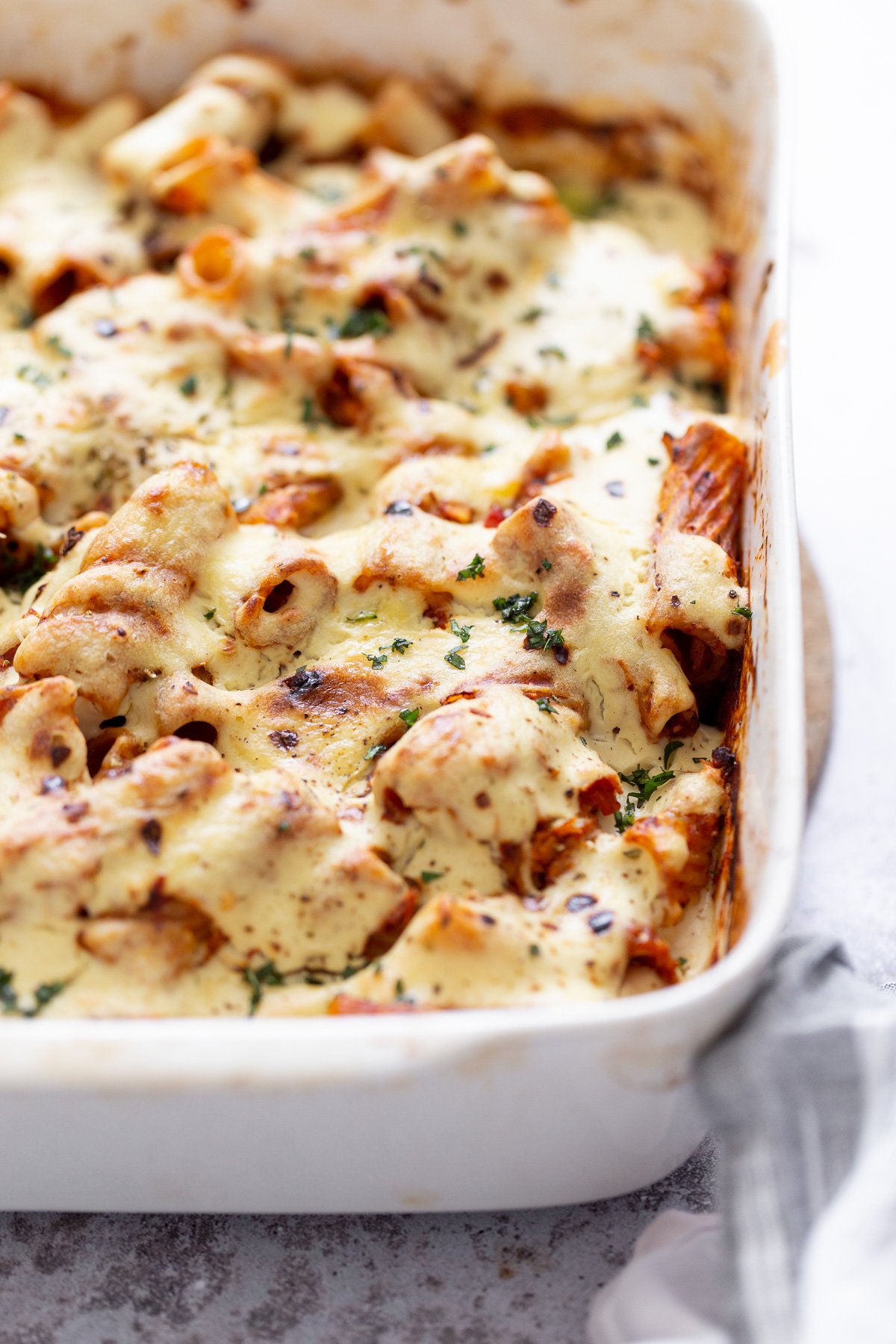 baked rigatoni side view of a casserole dish with baked vegan rigatoni with tofu mozzarella