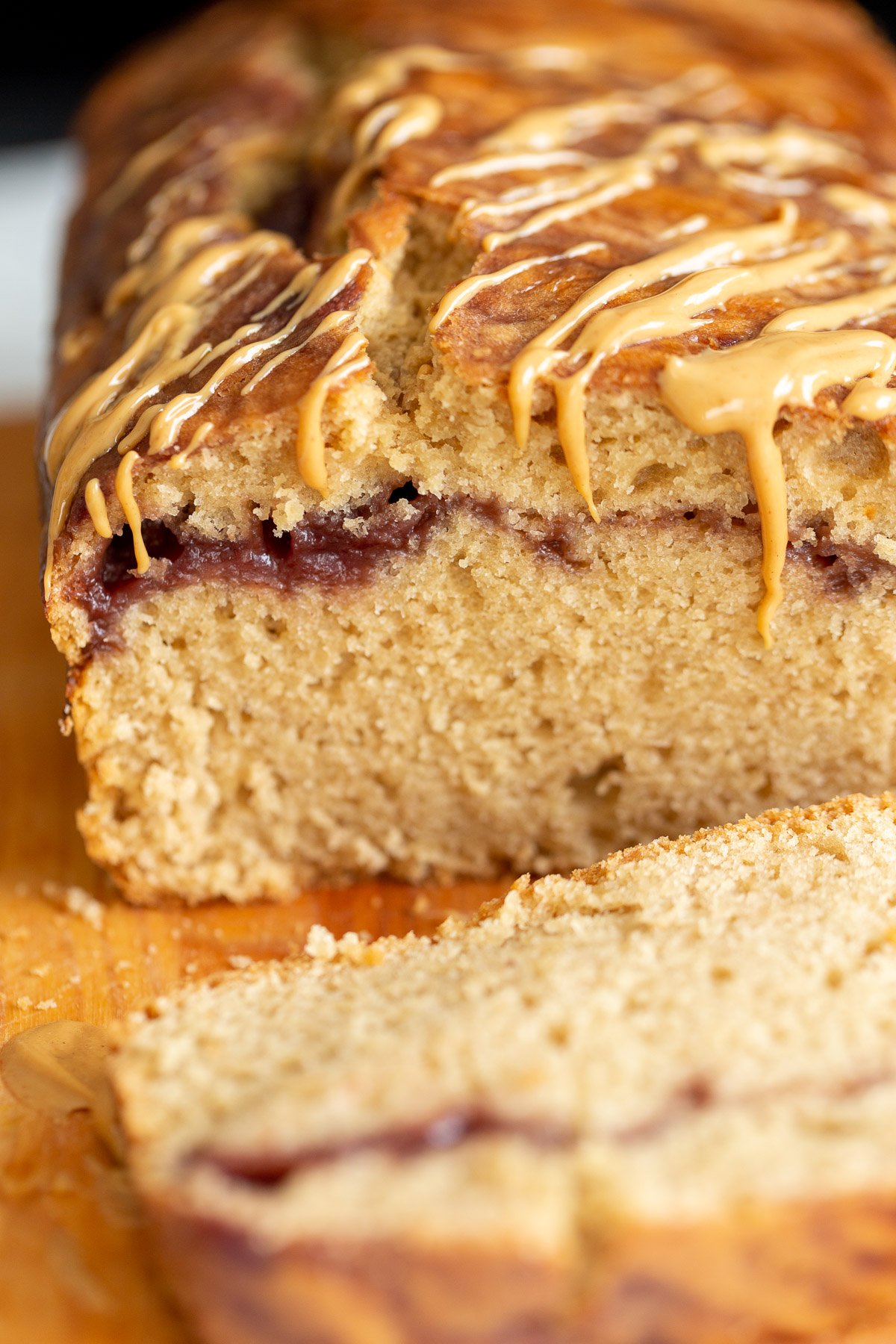 peanut butter and jelly cake  close up of a sliced loaf of vegan peanut butter and jelly cake with jam swirl