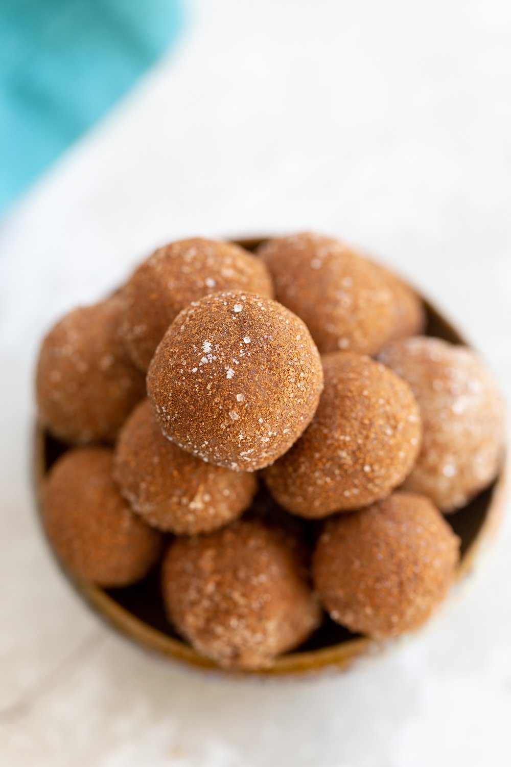 Snickerdoodle bites  overhead shot of a clay bowl with vegan Snickerdoodle bites rolled in cinnamon sugar