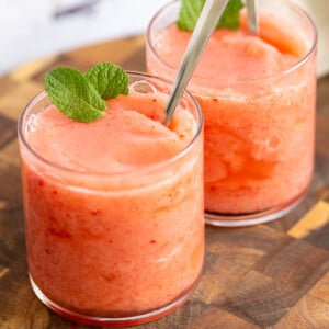 two glasses of vegan strawberry lemonade slushie with fresh mint leaves