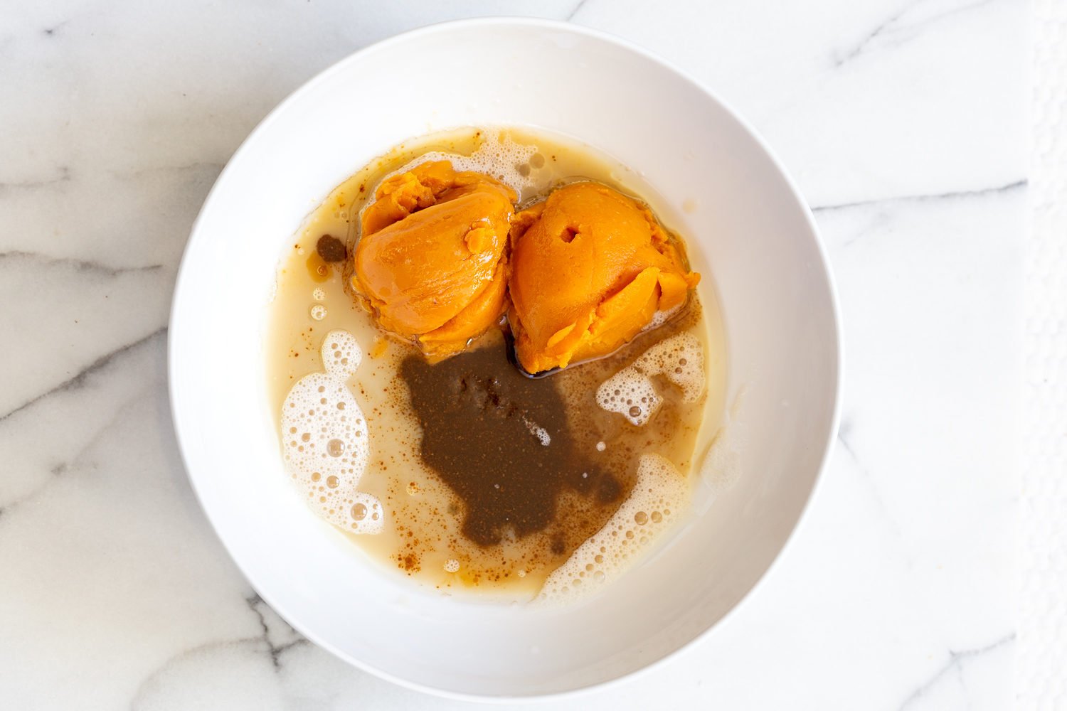 vegan carrot bread  wet ingredients for vegan pumpkin bread in a white bowl