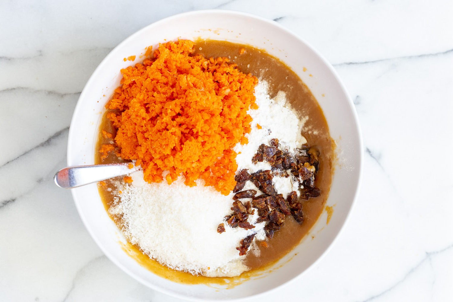 Ingredients for Batter for Vegan pumpkin carrot bread in a white bowl