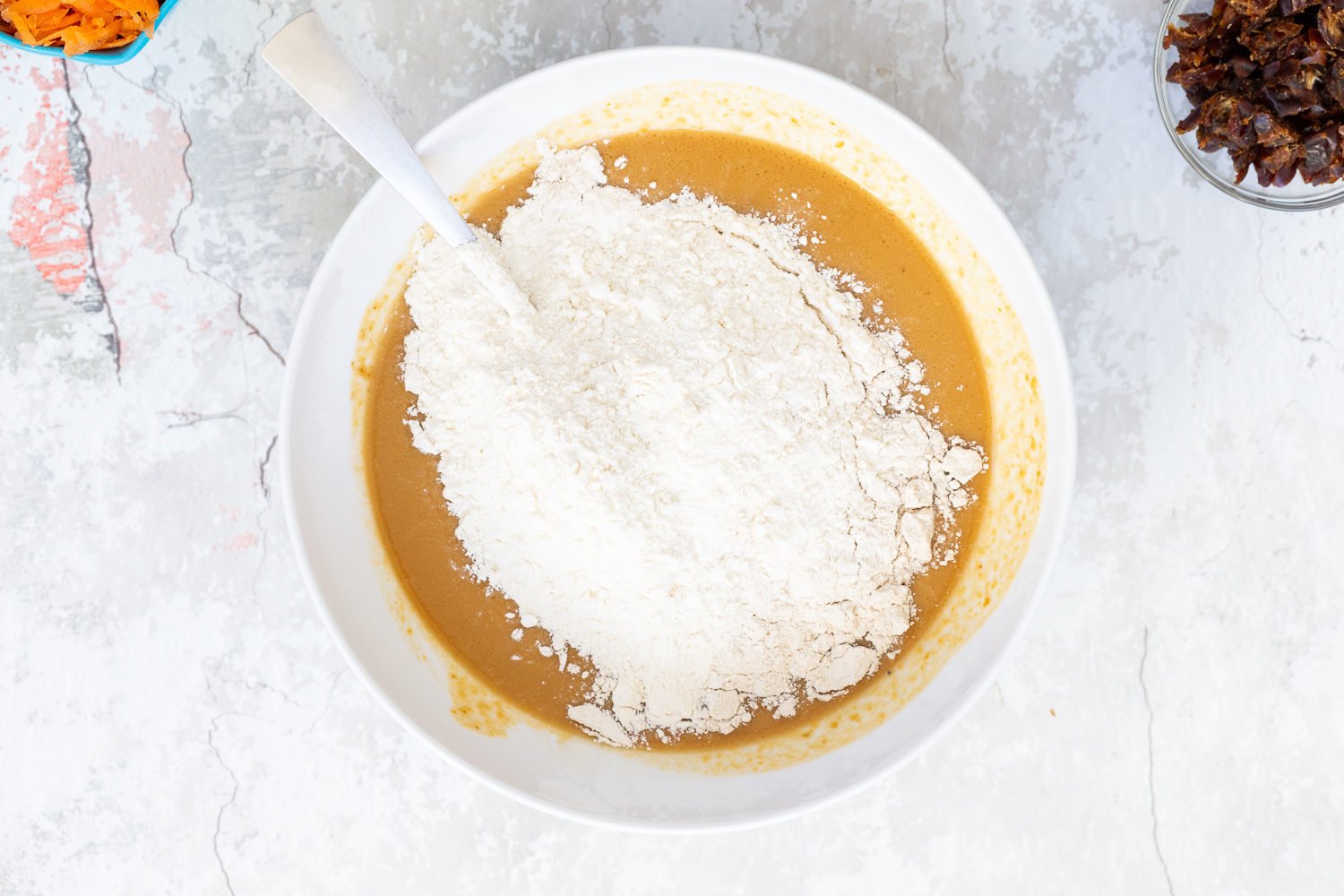 vegan carrot bread  flour being added to vegan carrot pumpkin bread batter