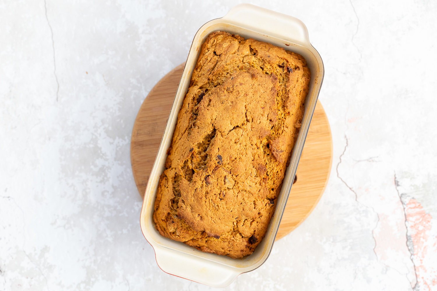vegan carrot bread  a freshly baked loaf of vegan pumpkin carrot bread cooling on a chopping board