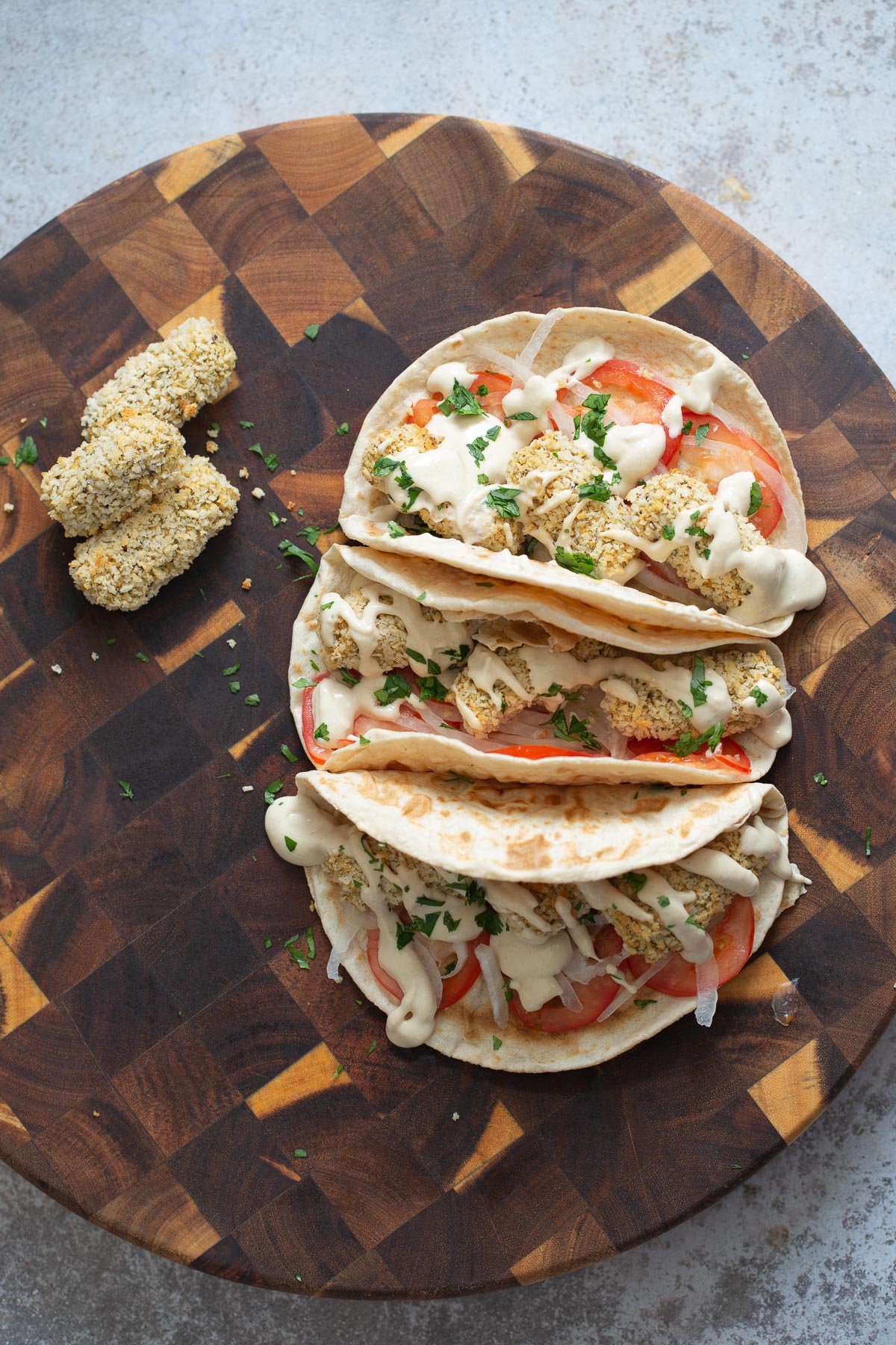 vegan croquettes  three wraps filled with vegan chickpea quinoa croquettes on a chopping board