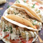 vegan chickpea croquettes served in tortillas drizzled with tahini dill sauce