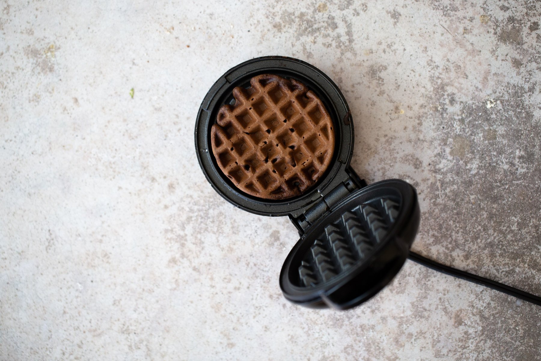 buckwheat waffles overhead shot of a waffle iron with a buckwheat waffle in it