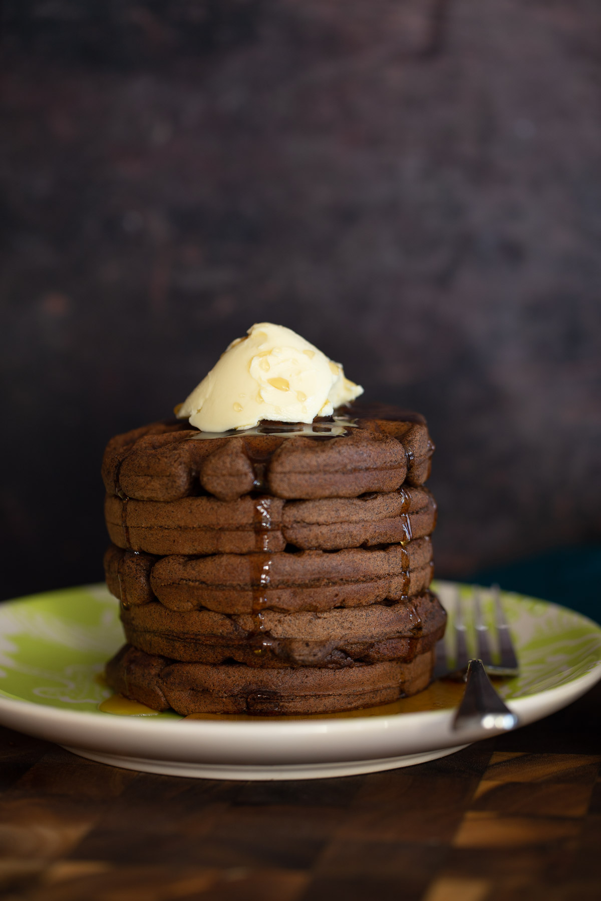 buckwheat waffles side view of a stack of chocolate buckwheat waffles topped with vanilla ice cream
