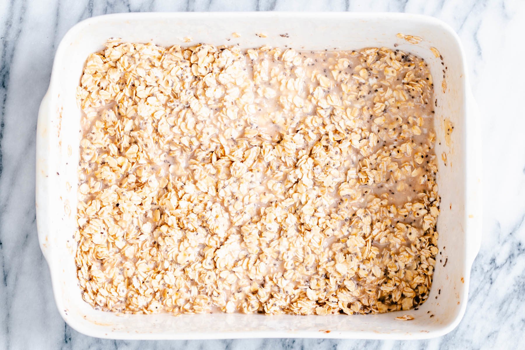 apple pie baked oatmeal oatmeal and chia seeds soaking in a casserole dish