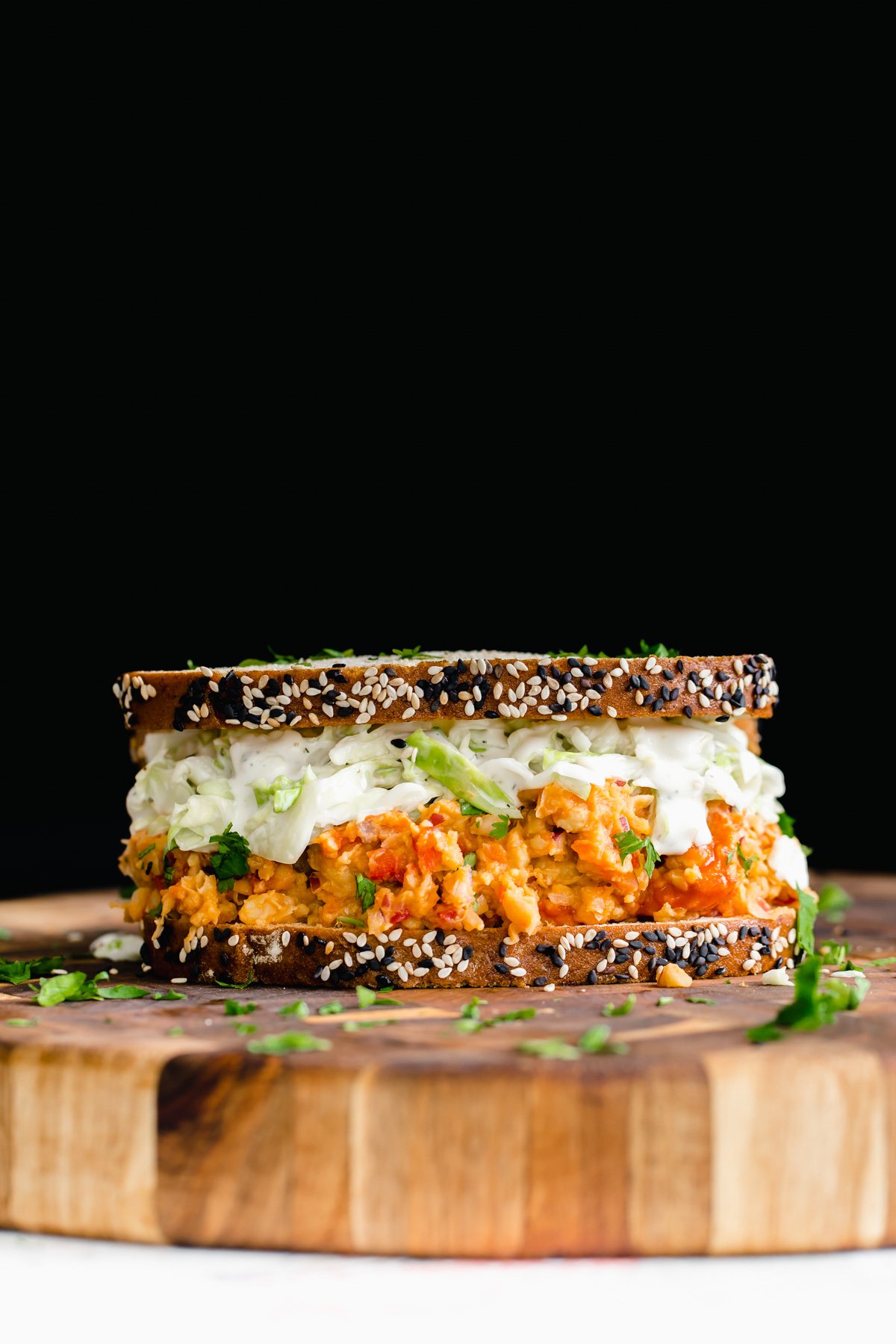 chickpea salad sandwich  side view of a vegan lunch sandwich with buffalo chickpea salad and slaw