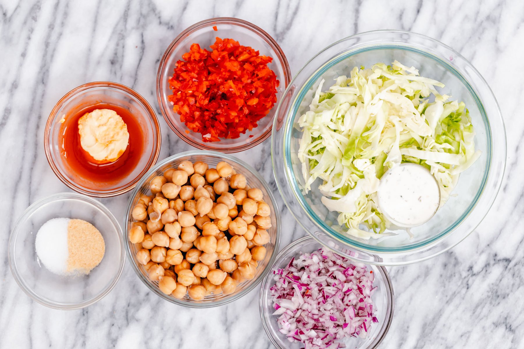 chickpea salad sandwich ingredients for buffalo chickpea salad sandwich assembled on a marble countertop