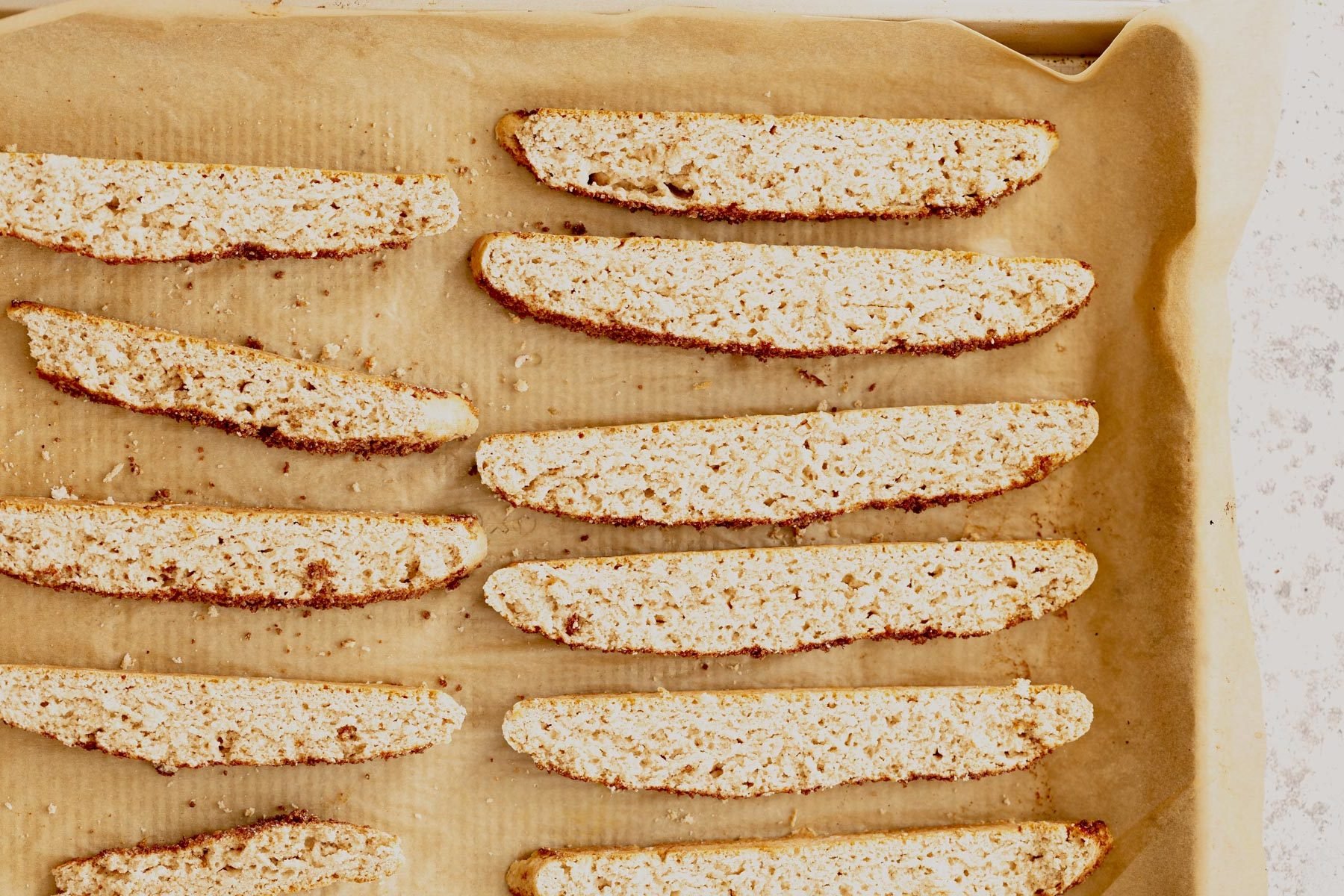 vegan biscotti vegan cinnamon sugar biscotti on a parchment paper lined baking sheet