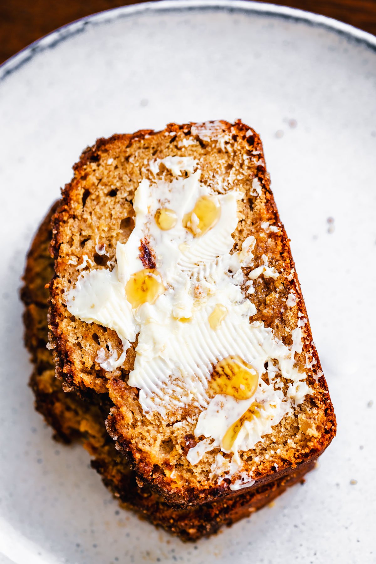 gingerbread banana bread a slice of buttered banana gingerbread on a white plate