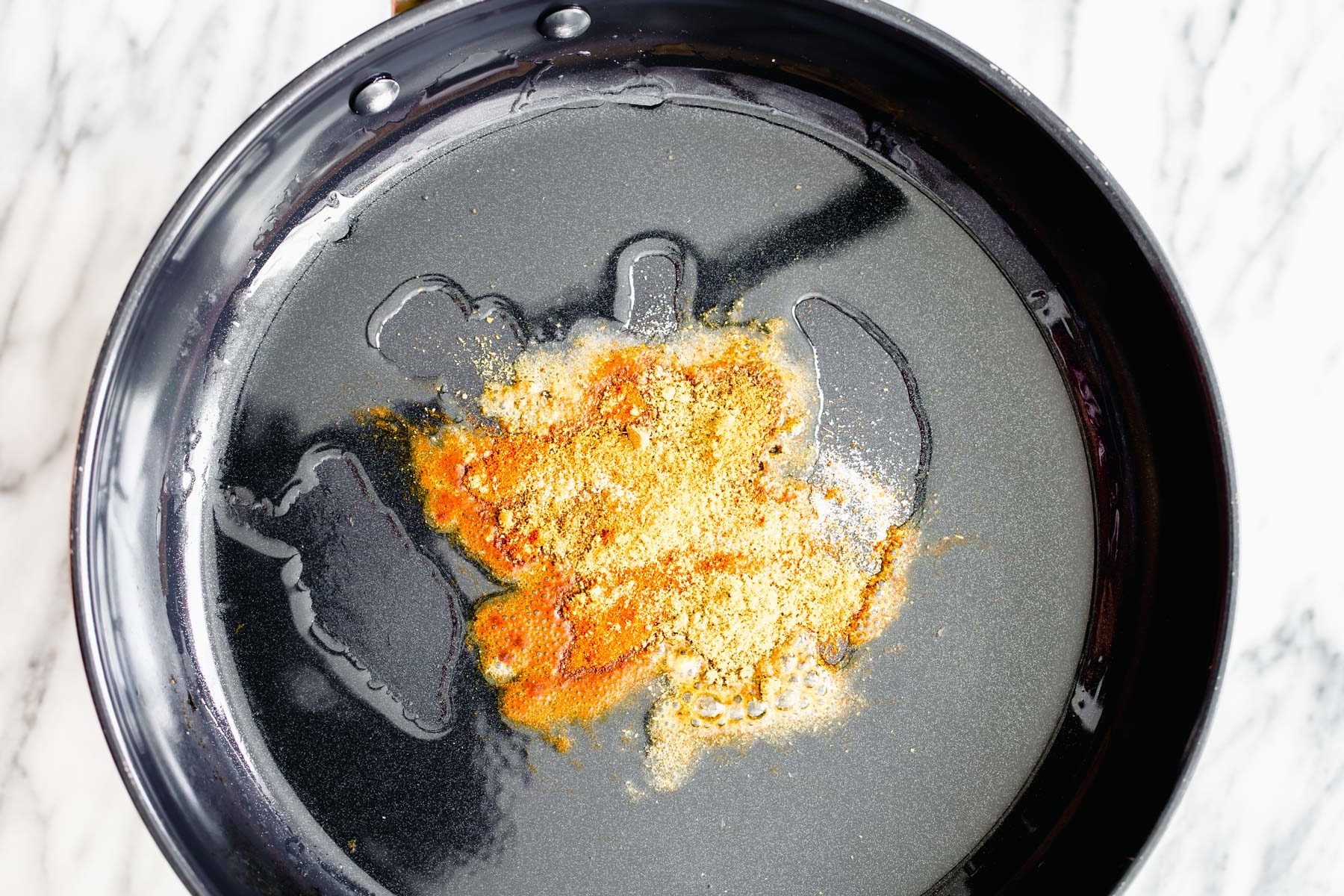 pumpkin curry  spices being added to hot oil for tempering