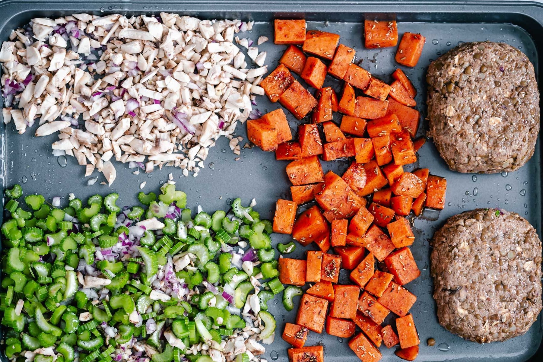 Thanksgiving sheet pan dinner overhead shot of vegan lentil loaves being placed on a baking sheet with side dishes