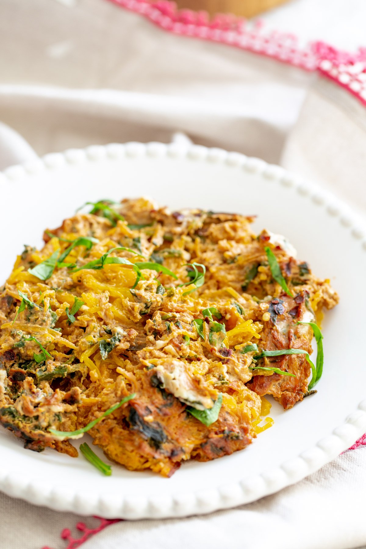 spaghetti squash bake  side view of a plate with vegan spaghetti squash bake with creamy tomato sauce