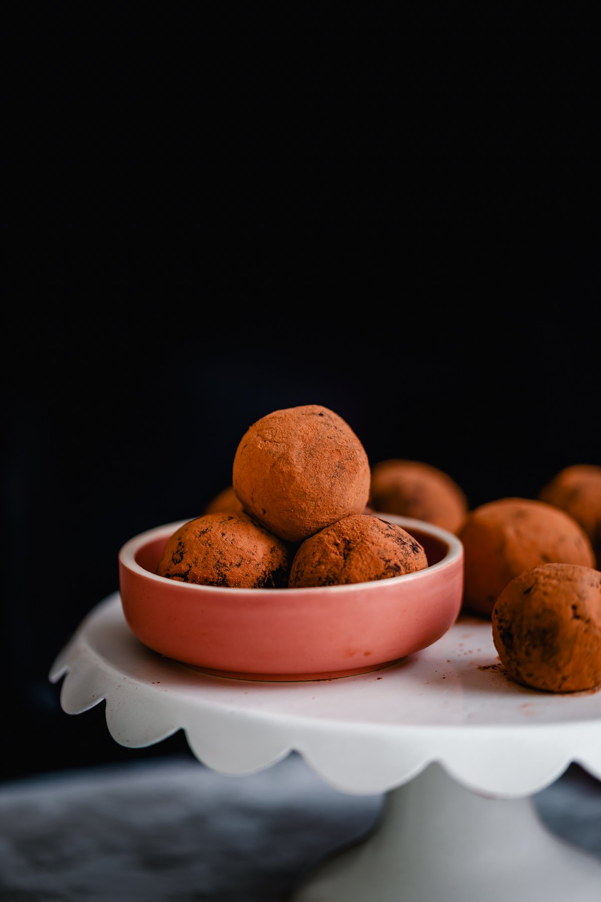 tiramisu truffles vegan homemade tiramisu truffles in a small pink bowl placed on a cake stand
