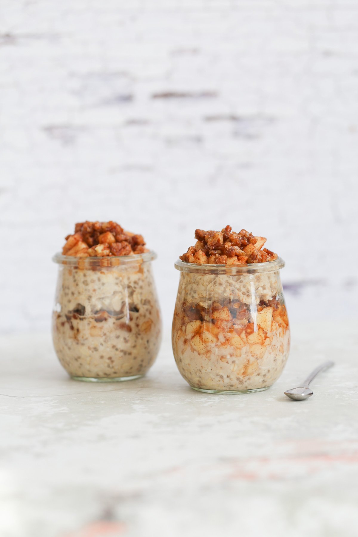 side view of apple cinnamon overnight oats in two mason jars 