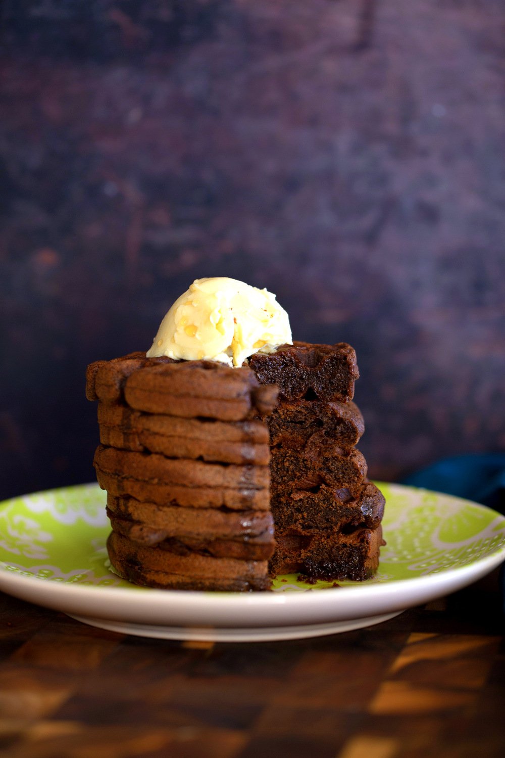 a stack of glutenfree chocolate buckwheat waffles topped with vanilla ice cream
