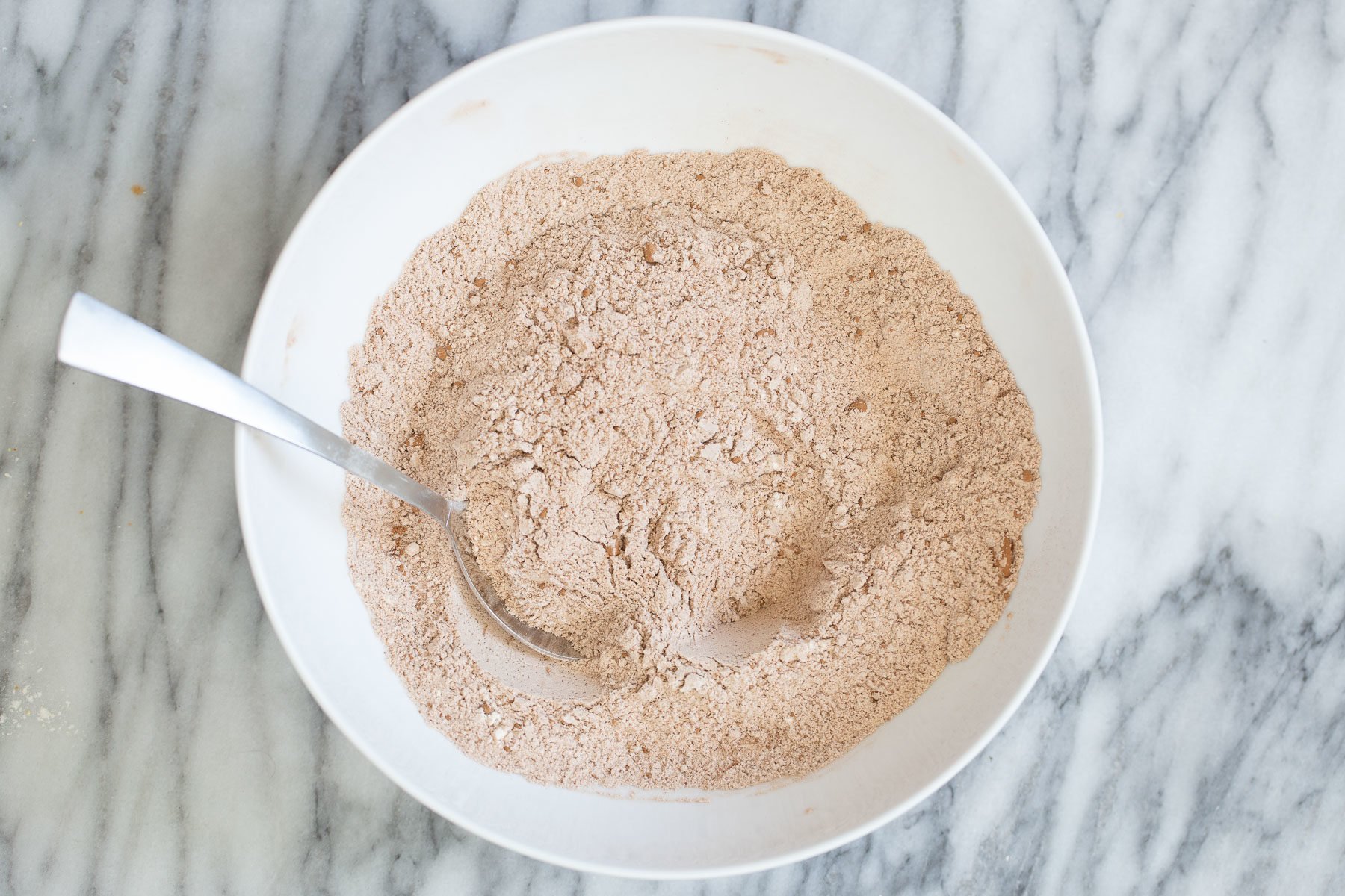 chocolate zucchini bread  dry ingredients for chocolate zucchini bread in a white bowl