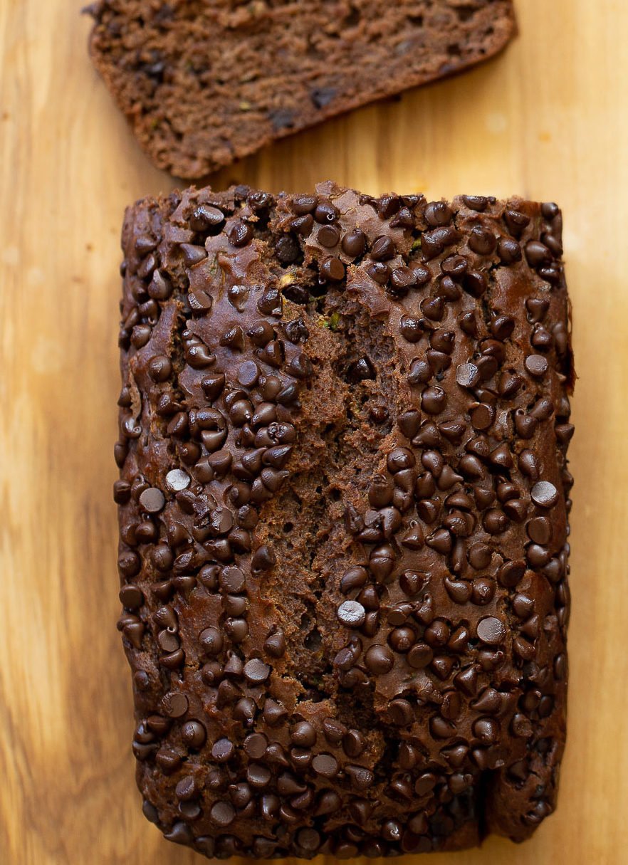 chocolate zucchini bread  overhead shot of a loaf of vegan chocolate zucchini bread on a chopping board