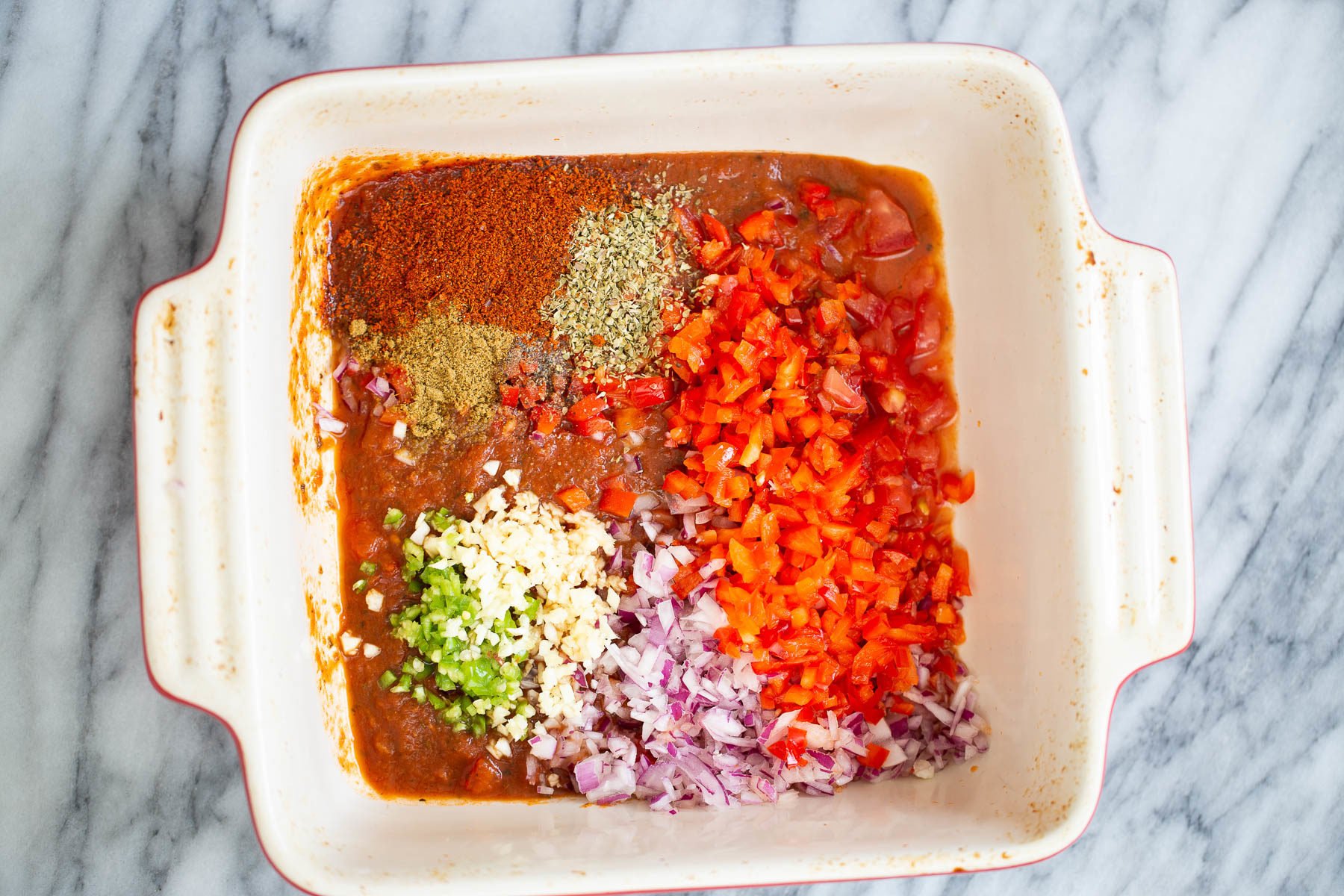 chili cornbread casserole chili mix being tossed in a white casserole dish