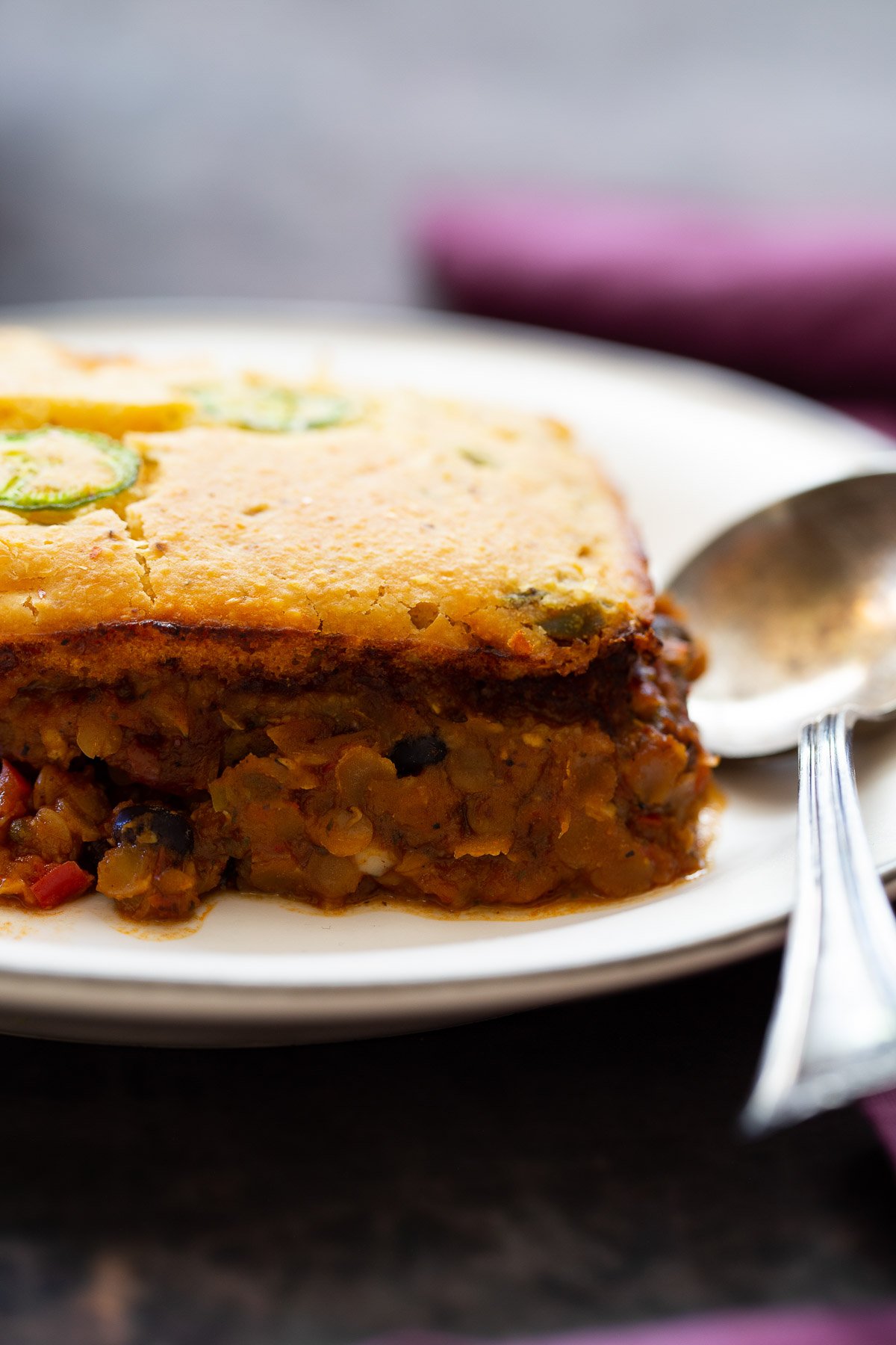 chili cornbread casserole side view of a slice of chile cornbread casserole on a white plate