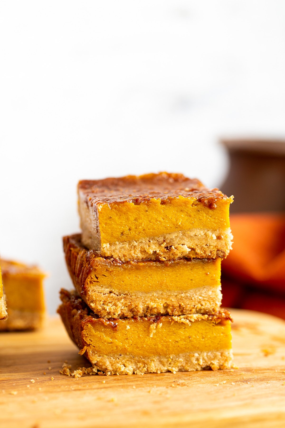 stacked vegan pumpkin pie bars on a wooden board