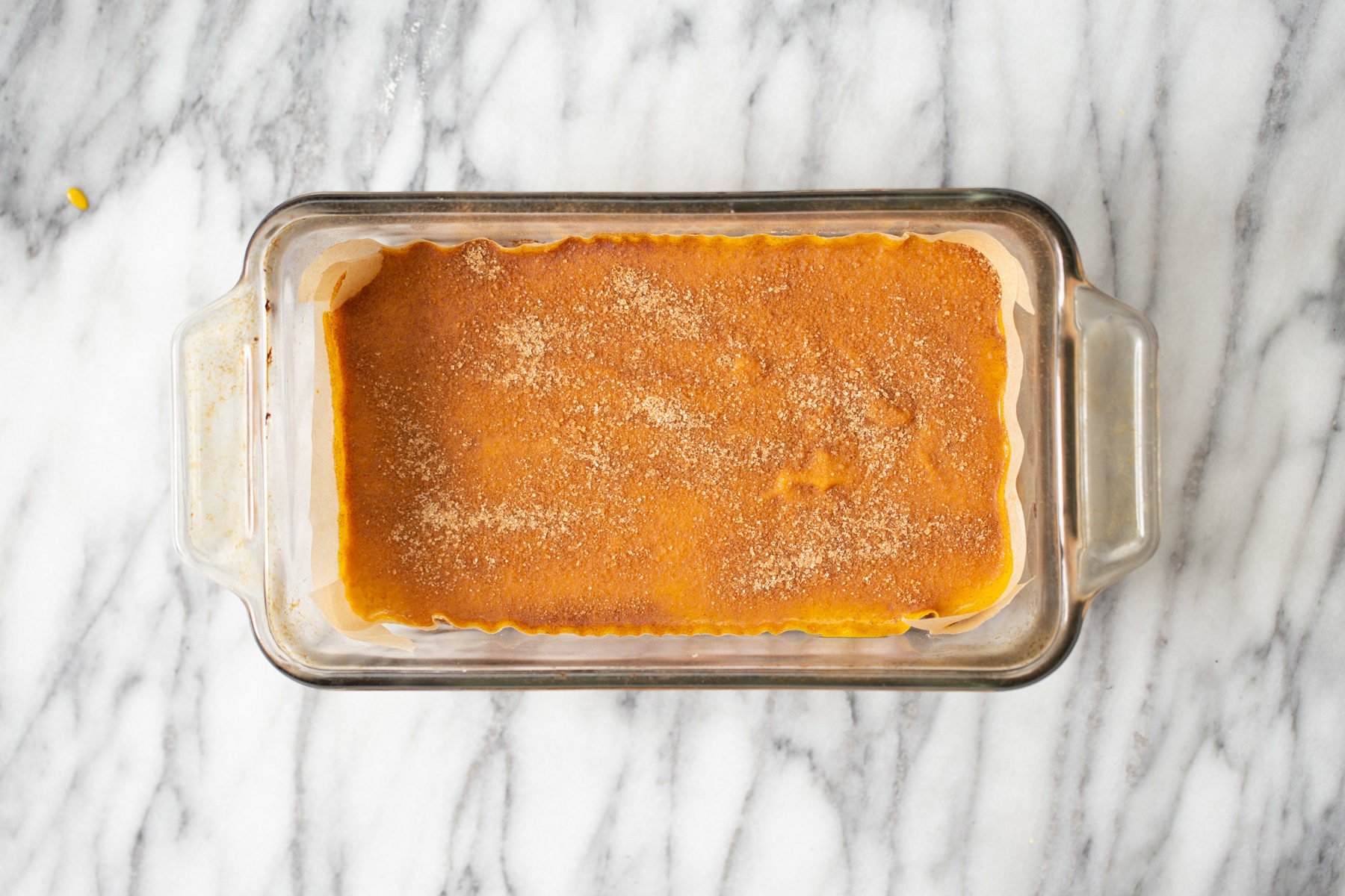 vegan pumpkin pie bars pumpkin pie filling being added to crust in loaf pan