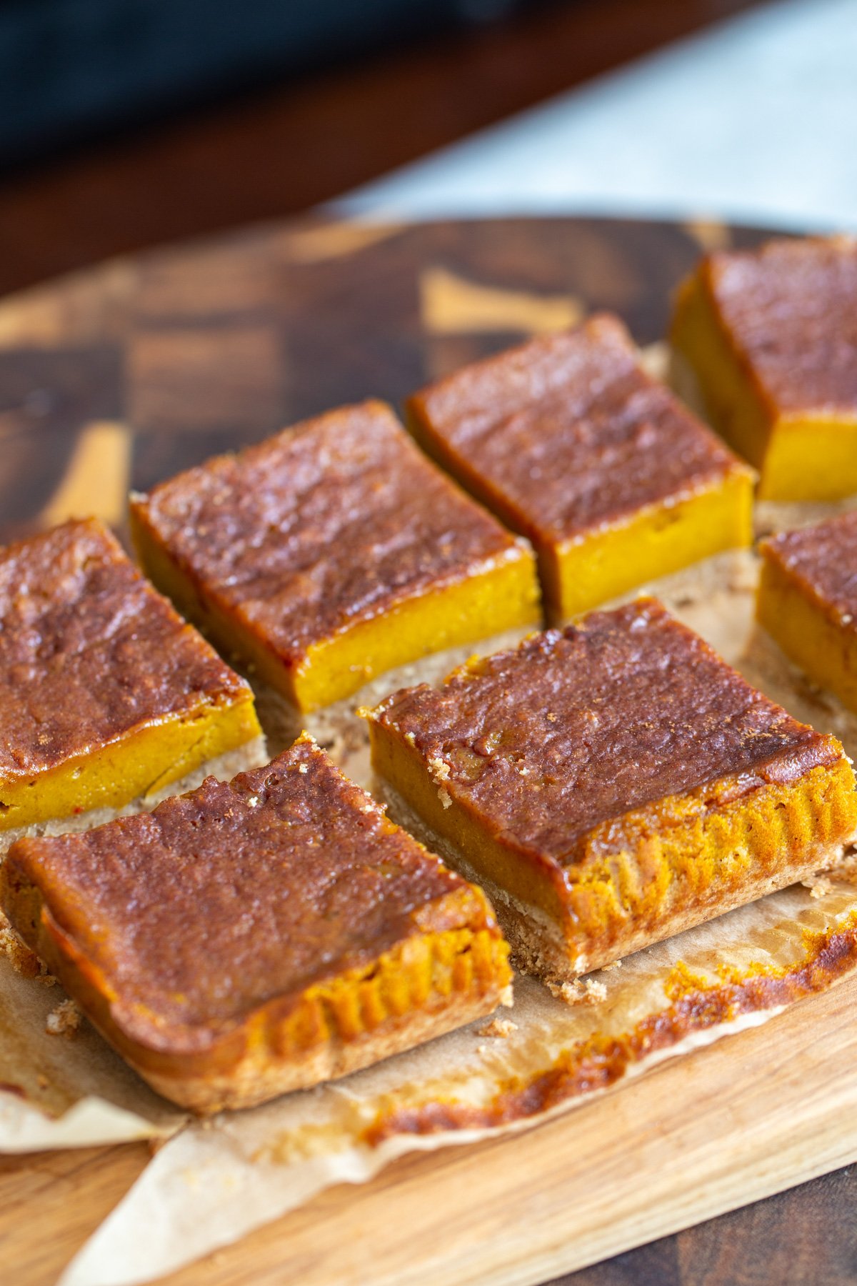 vegan pumpkin pie bars sliced vegan pumpkin pie bars arranged on a piece of parchment paper