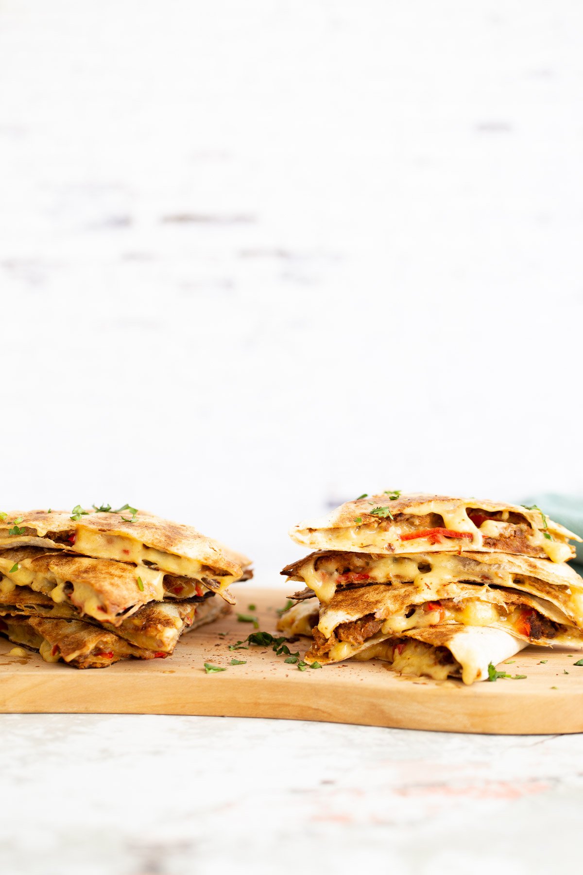 walnut taco meat two stacks of quesadillas filled with vegan walnut taco meat on a chopping board
