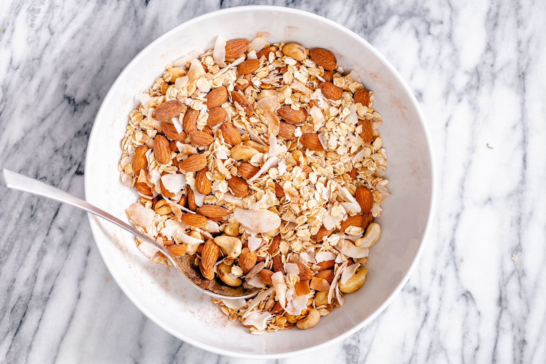 coconut granola dry granola ingredients being mixed in a small bowl