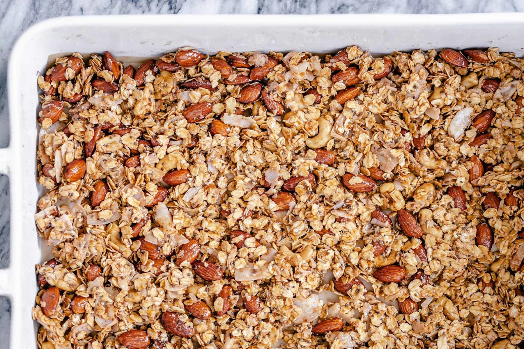 coconut granola  overhead shot of a casserole dish with baked almond coconut granola